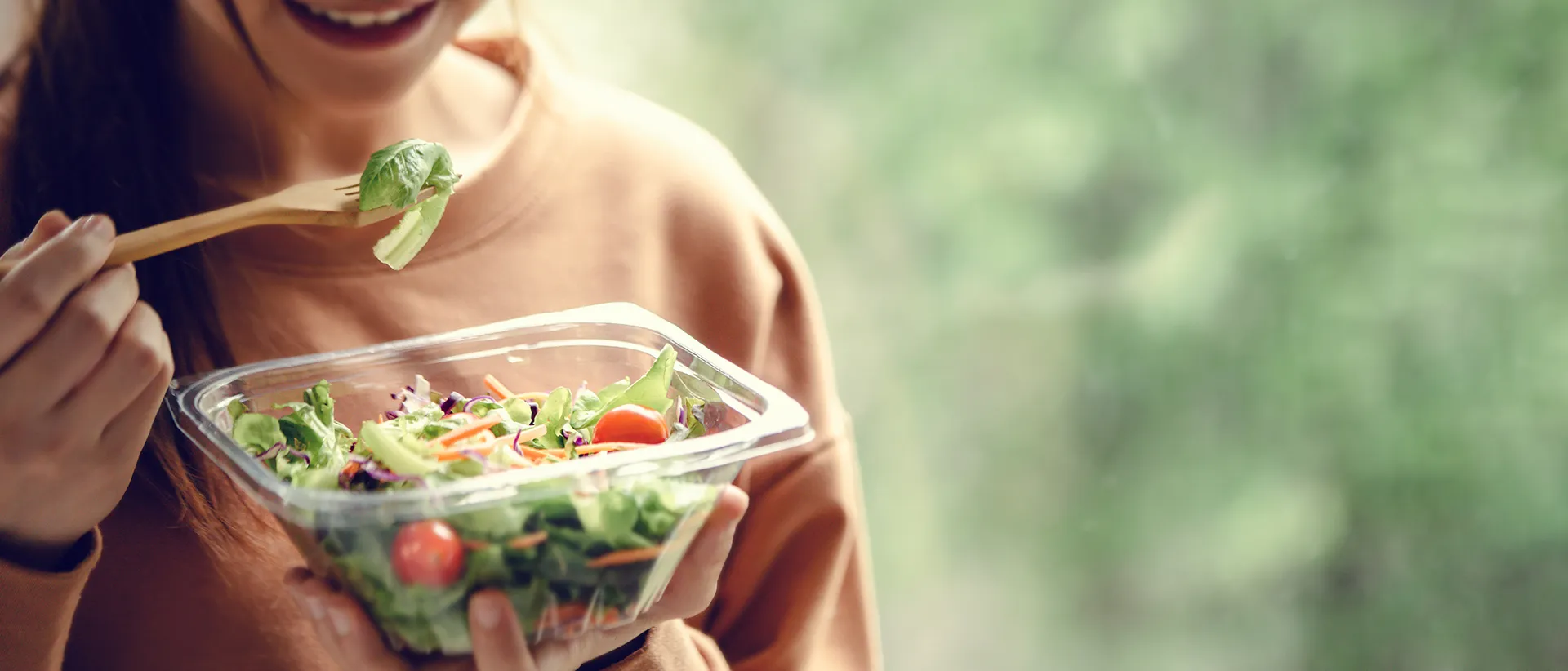 A girl eating a bowl of salad - summer diet plan.