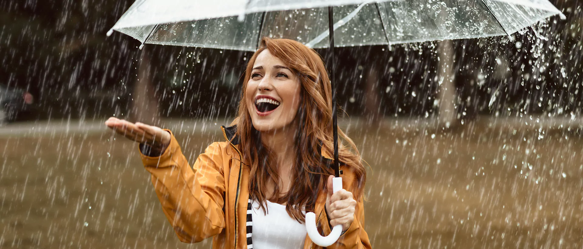 Rainy season skin care - girl holding an umbrella in the rain.