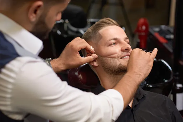 Man getting full face threading done at a salon.
