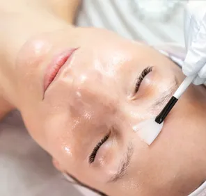 Woman getting a face peel treatment at a cosmetic skin care clinic.
