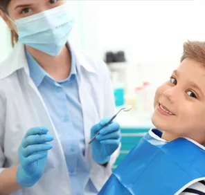 A pediatric dentist in Hyderabad carries out preventive dental care procedures for a young boy.
