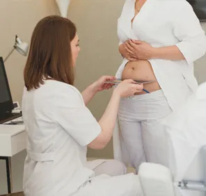 Woman at a skin and hair clinic getting examined for stretch marks.
