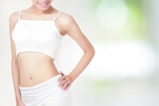 A woman is pleased with her flat stomach following inch loss treatment. 
