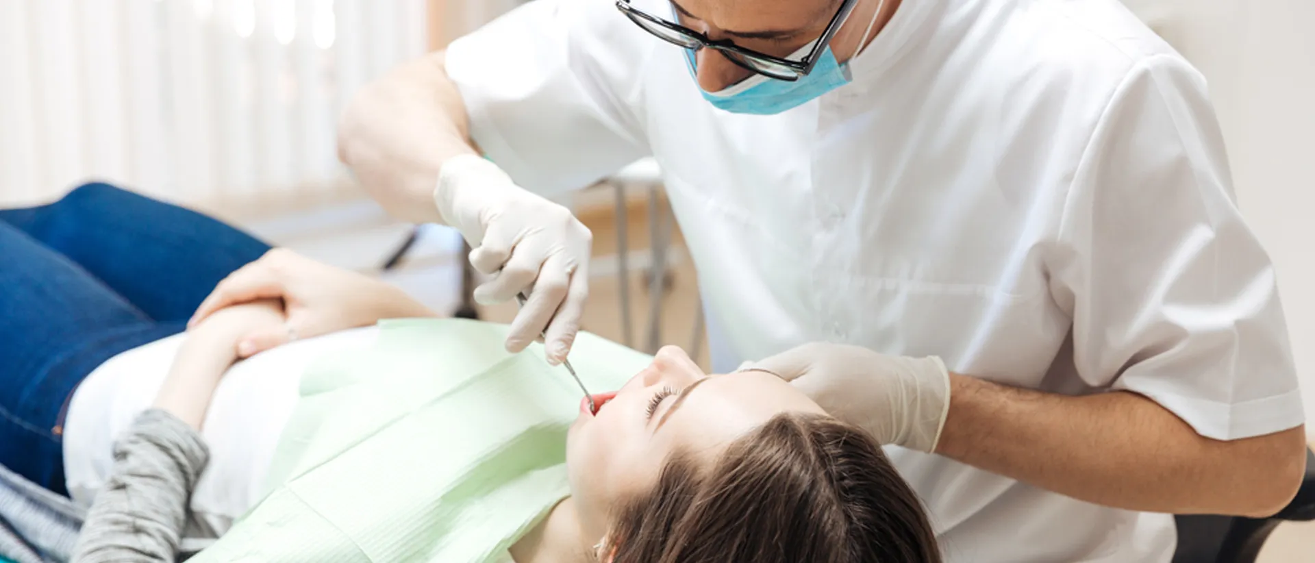 A dentist examining a patient at a dental care clinic.
