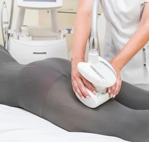A healthcare professional uses advanced equipment for firming treatment at a slimming clinic in Hyderabad.