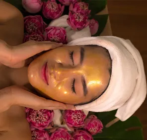 Lotus Cleanup at parlour - woman with face pack on her face.
