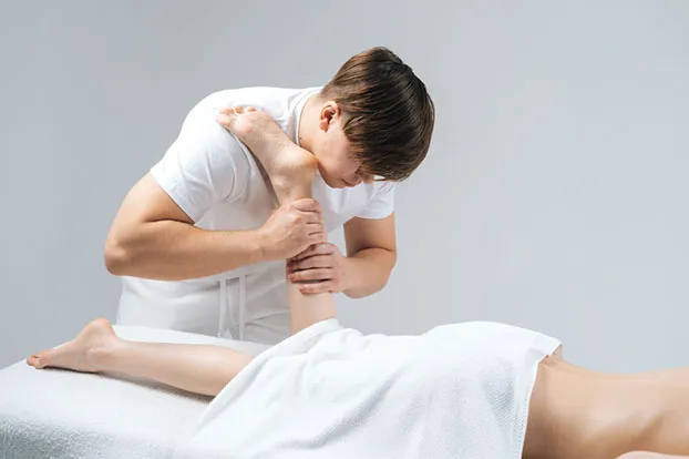 Treatment with massage for muscle strain in the legs
