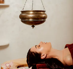 A woman rests on a wooden table at an ayurvedic massage centre in Hyderabad.
