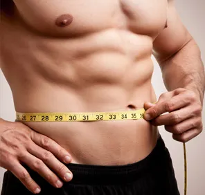 Healthy weight gain - A muscular man takes waist measurements.  
